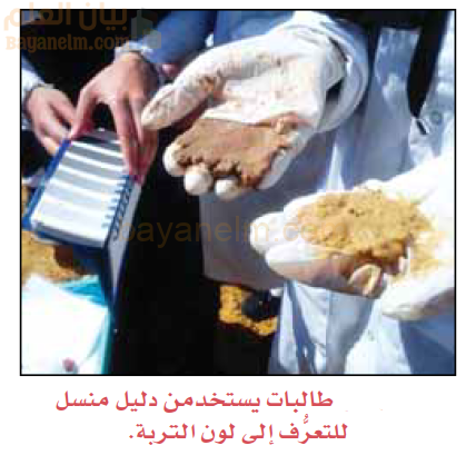 طالبات يستخدمن دليل منسل للتعرف الى لون التربة